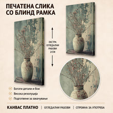 Вчитај ја сликата во галериски мод за гледање, Рустична керамичка вазна со нежни цветни гранки на маса, пред текстуриран зеленкаст ѕид со сенки.